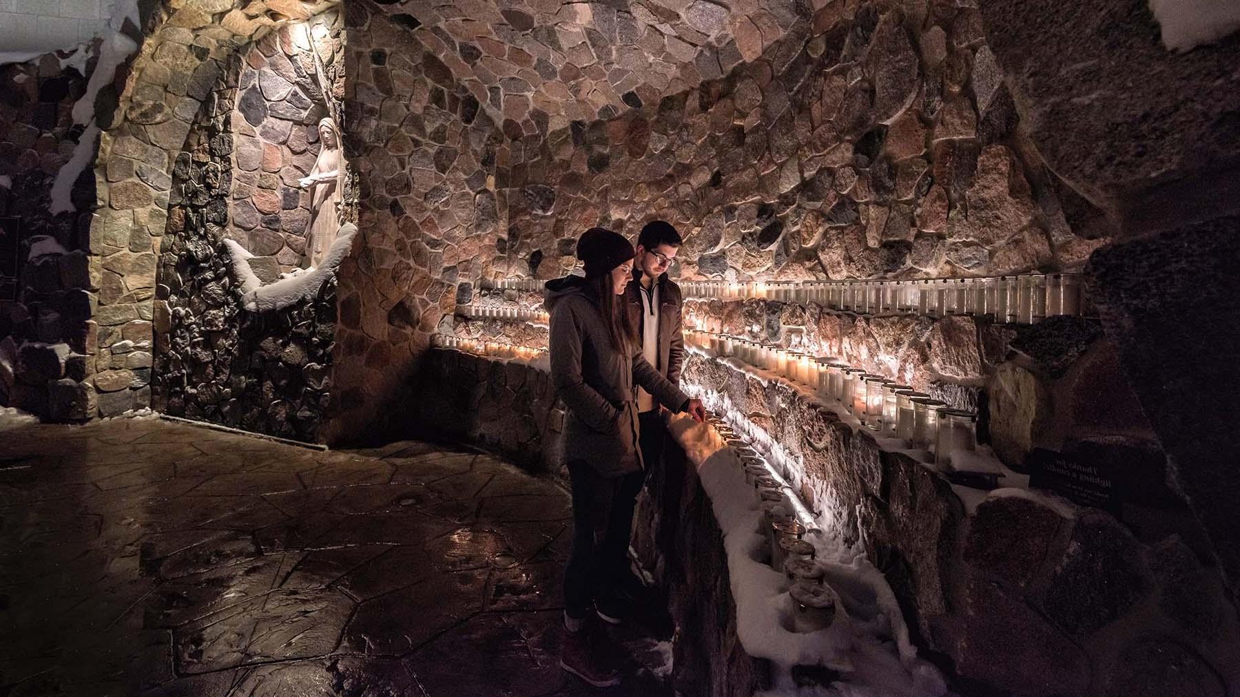 两个学生在洞穴里点蜡烛 
